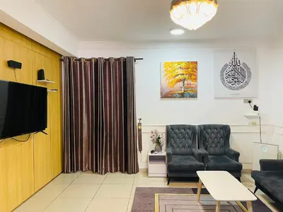 a living room with a couch and a television at NO 121 NAZIRIN HOMESTAY TMN DESA MANJUNG in Lumut