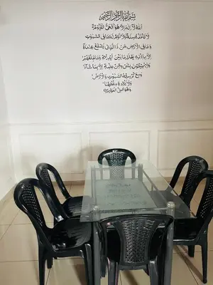 a glass table with four black chairs in a room at NO 121 NAZIRIN HOMESTAY TMN DESA MANJUNG in Lumut