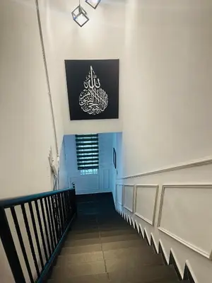 a hallway with a staircase with a sign on the wall at NO 121 NAZIRIN HOMESTAY TMN DESA MANJUNG in Lumut