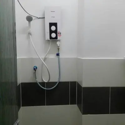a shower in a bathroom with a hose on the wall at Izwana Muslim Homestay in Tanah Rata