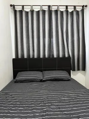 a bedroom with a bed with a black and grey curtain at Izwana Muslim Homestay in Tanah Rata