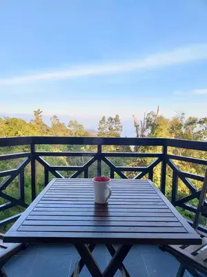 a coffee cup sitting on a wooden table on a balcony at Fraser Hill Silverpart Resort A3-1-1 Forest View With Lift in Bukit Fraser