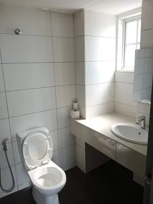a white bathroom with a toilet and a sink at Fraser Hill Silverpart Resort A3-1-1 Forest View With Lift in Bukit Fraser