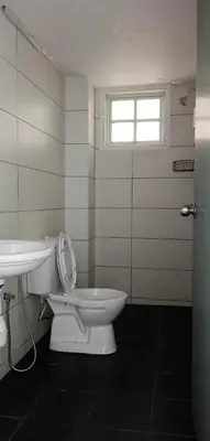 a bathroom with a toilet and a sink and a window at Fraser Hill Silverpart Resort A3-1-1 Forest View With Lift in Bukit Fraser