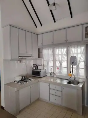 a kitchen with white cabinets and a sink and a stove at Fraser Hill Silverpart Resort B2-6-1 Forest View High Floor No Lift in Bukit Fraser