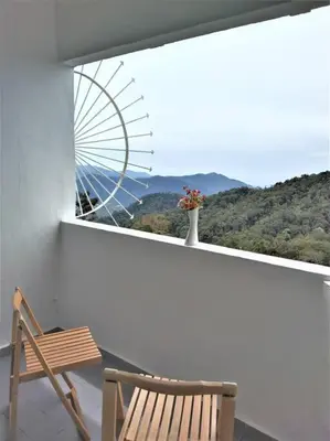 a chair and a vase on a balcony with a window at Fraser Hill Silverpart Resort B2-6-1 Forest View High Floor No Lift in Bukit Fraser
