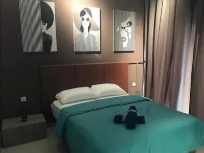 a bedroom with a bed with four pictures on the wall at R&C Guesthouse in Ipoh