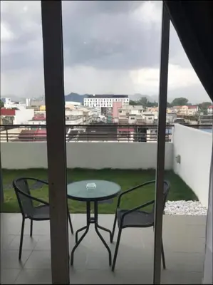a table and two chairs on a balcony with a view at R&C Guesthouse in Ipoh