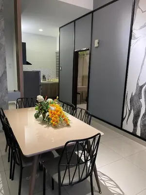 a dining room table with a vase of flowers on it at R&C Guesthouse in Ipoh