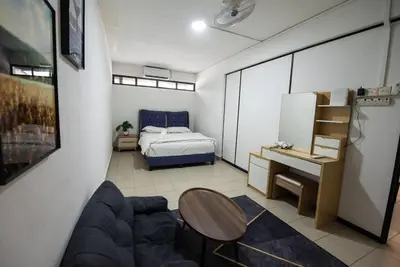 a room with a bed and a table and a couch at De Luma (The Rumah)@3bedroom (Sunflower) in Bukit Mertajam