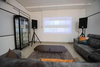 a living room with a couch and a projection screen at De Luma (The Rumah)@3bedroom (Sunflower) in Bukit Mertajam