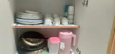 a cupboard with plates and dishes and a toilet at Emily Homestay Cameron Highlands in Tanah Rata
