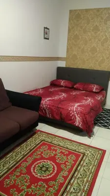a bedroom with a red bed and a red rug at Emily Homestay Cameron Highlands in Tanah Rata
