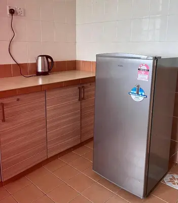 a kitchen with a stainless steel refrigerator with stickers on it at Cameron Crown Imperial Court @ Brinchang in Brinchang