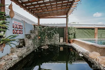 a swimming pool with a wooden pergola next to a house at Ipoh 27 Private Pool Villa By Verve EECH118 in Ipoh