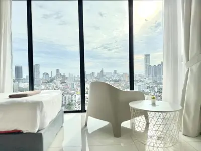 a bedroom with a bed and a table in front of a window at Beacon Executive Suites #Warmth #SkyPool #Georgetown #5pax #2BR 2bath #2Queen 1Single #Quality well maintained #Private host in George Town