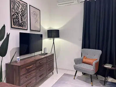 a living room with a television and a chair at Ojies Onsen - 3 guest only in Ipoh