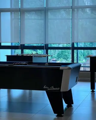 a pool table sitting in a room with windows at Ojies Onsen - 3 guest only in Ipoh