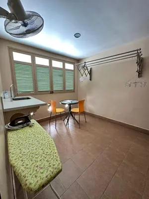 a living room with a table and chairs and a ceiling fan at Popus Heritage Townhouse, Georgetown in George Town