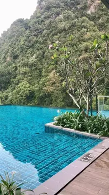 a swimming pool with a mountain in the background at Onsen Suits HJM @ Sunway Ipoh in Ipoh