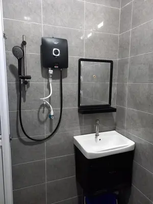 a bathroom with a shower with a sink and a mirror at Yaths homestay in Butterworth