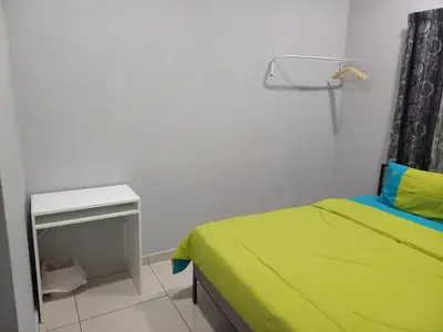a bedroom with a bed and a night stand and a table at Yaths homestay in Butterworth