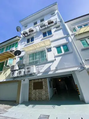 a large white building with a garage in front of it at Nautilus Bay Home Inn in George Town