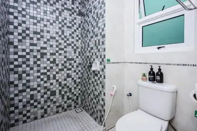 a bathroom with a toilet and a window at Nautilus Bay Home Inn in George Town