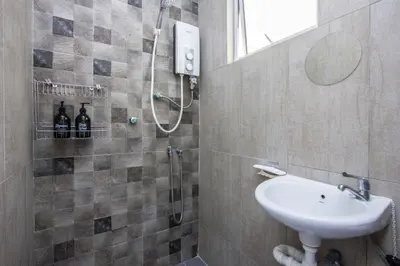 a bathroom with a shower and a sink at Nautilus Bay Home Inn in George Town