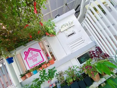 a sign on the front of a house with plants at Nautilus Bay Home Inn in George Town