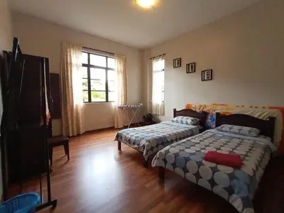 a living room with two beds and a television at Aspen Holiday Apartment in Tanah Rata