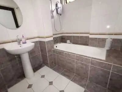 a bathroom with a sink and a bath tub at Aspen Holiday Apartment in Tanah Rata