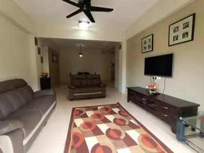 a living room with a couch and a flat screen tv at Aspen Holiday Apartment in Tanah Rata