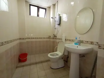 a bathroom with a sink and a toilet and a mirror at Aspen Holiday Apartment in Tanah Rata