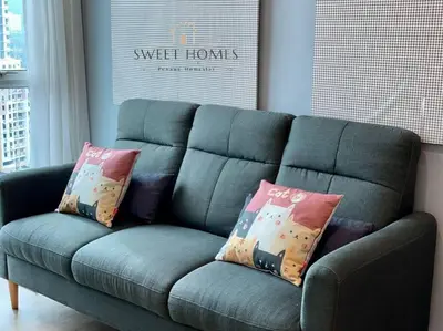 a blue couch with pillows on it in a living room at HolidayCozy StraitsGardenSuite Penang#6pax#family in George Town