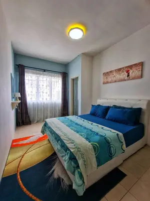 a bedroom with a bed with blue sheets and a window at Amrich Staycation Muslim Cameron Highlands in Tanah Rata