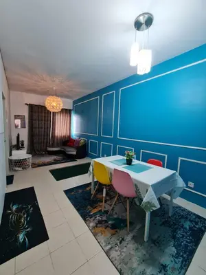 a dining room with a blue wall with a table and chairs at Amrich Staycation Muslim Cameron Highlands in Tanah Rata