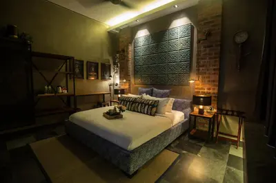 a bedroom with a bed and a brick wall at Carrot Seed in Ipoh
