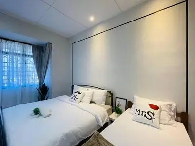 two beds in a room with white sheets and pillows at Ipoh 42 Symphony 12pax 4Bedroom 3bathroom 3carpark in Ipoh