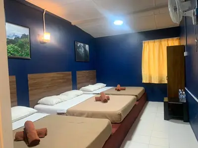 three beds in a room with blue walls at Vintage Guesthouse in Tanah Rata
