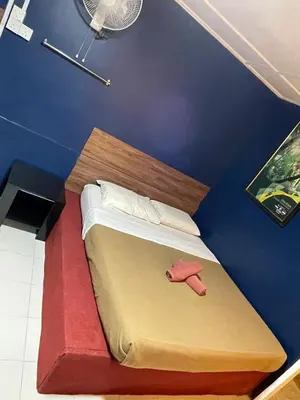 a bed in a room with a blue wall at Vintage Guesthouse in Tanah Rata