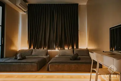 a living room with two beds in front of a window at Ipoh Tambun Lost World Onsen by Verve in Tambun