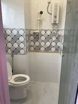 a bathroom with a toilet and a phone on the wall at Cameron Homestay Adik Aisyah Purple Romance for Islam in Tanah Rata