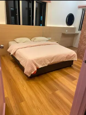 a large bed in a room with a wooden floor at Cameron Homestay Adik Aisyah Purple Romance for Islam in Tanah Rata