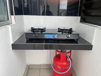 a stove in a kitchen with a red fire hydrant at Cameron Homestay Adik Aisyah Purple Romance for Islam in Tanah Rata