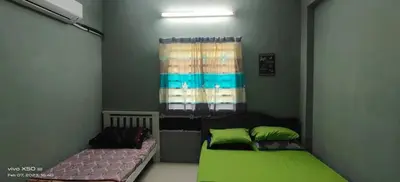 a bedroom with a green bed and a window at Homestay Lumut Perak 2026 in Lumut