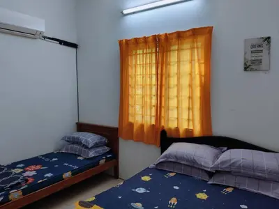 a bedroom with two beds and a window at Homestay Lumut Perak 2026 in Lumut