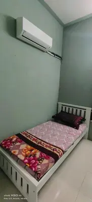 a small bedroom with a bed with pink sheets at Homestay Lumut Perak 2026 in Lumut
