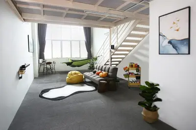 a living room with a couch and a staircase at Private 100 inches Screen Cinema at CEO Penang in Bayan Lepas