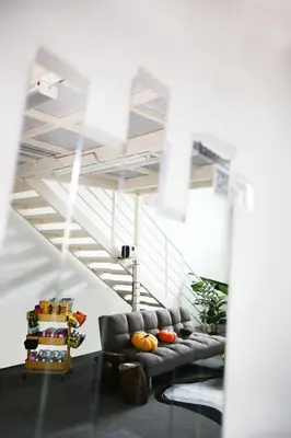 a living room with a couch and a staircase at Private 100 inches Screen Cinema at CEO Penang in Bayan Lepas